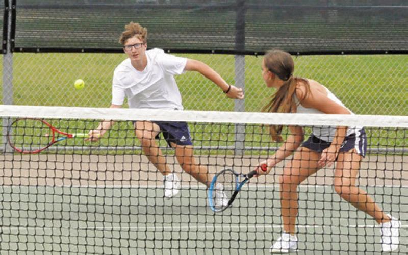 CALDWELL’S CAYDEN ZBORIL runs to return the ball as his mixed doubles teammate Kylie Vogler looks on during their first round match at last week’s Class 4A Region 3 Tennis Tournament in Bryan.