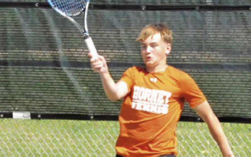 PARKER WHITE plays the ball at the net during a boys doubles match at the Class 4A Region 3 Tennis Tournament at Rudder High School. -- Tribune photo by Denise Squier