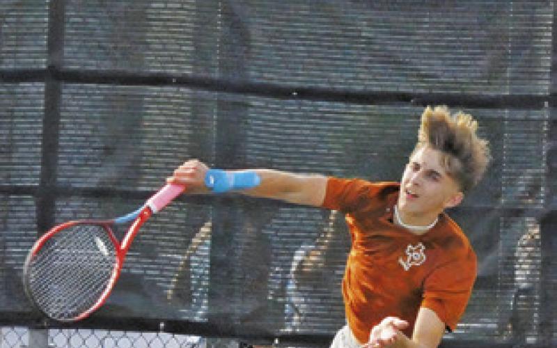 DYLAN CHAPMAN serves during his first round boys singles match at last week’s Class 4A Region 3 Tennis Tournament at Rudder High School. -- Tribune photo by Denise Squier