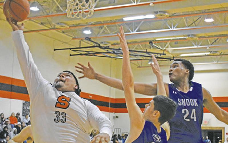 SOMERVILLE’S JESUS ESPINOZA shoots as Snook’s Josh Green and Dekendrick Dawson defend. -- Tribune photo by Roy Sanders