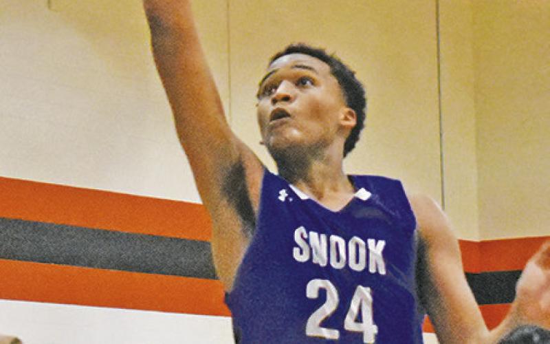 SNOOK’S DEKENDRICK Dawson takes a shot as Somerville’s Jesus Espinoza and Gardner Shivers defend. Somerville won 71-61.