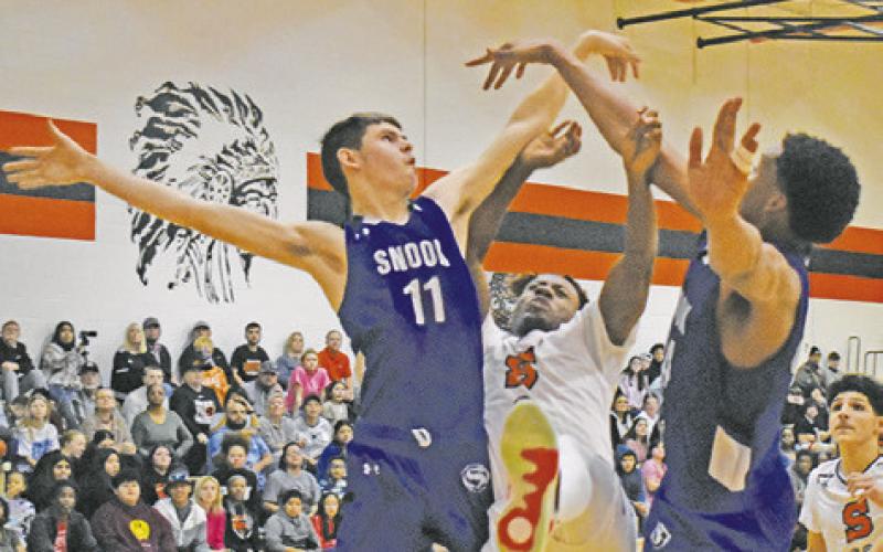 SNOOK’S JOSH GREEN and Dekendrick Dawson and Somerville’s D.J. Bryant fight for the ball in Somerville’s 71-61 victory.
