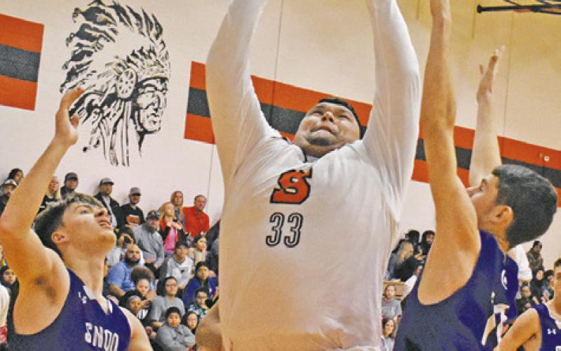 SOMERVILLE’S JESUS ESPINOZA takes a shot as Snook’s Sam Smitherman and Josh Green defend. Somerville won 71-61.