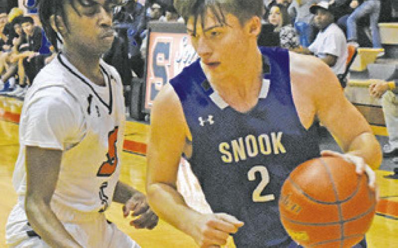 SNOOK’S SAM SMITHERMAN dribbles the ball past Somerville’s Brandyn Carter.