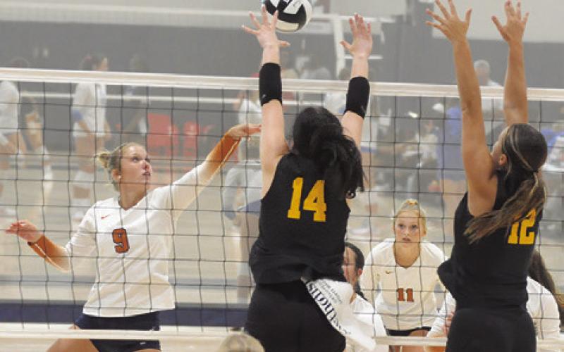 CALDWELL’S MOLLY MEADOWS hits the ball into the hands of Klein Oak’s Tori Leggeiro and Ava Marr during Caldwell’s match against Klein Oak at last week’s Legends Invitational tournament. Tribune photo by Denise Squier