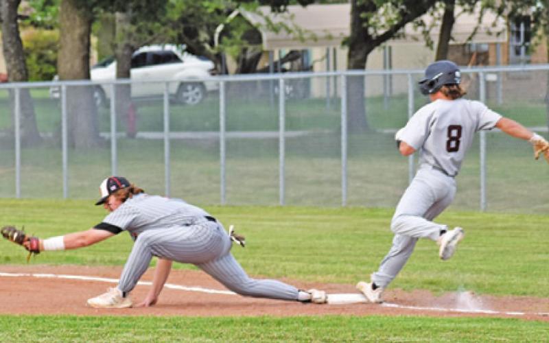 SOMERVILLE FIRST BASEMAN Cullen Sablatura reaches for the ball as this Iola player reaches base. -- Tribune photo by Roy Sanders