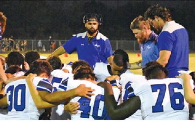 SNOOK’S PLAYERS AND coaches gather for prayer for teammate Jimmy Kearney following his injury at Normangee. Tribune photo by Roy Sanders