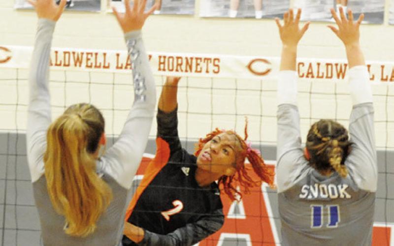 SOMERVILLE’S RA’MAYA CARTER gets one of her 13 kills last Friday against Snook. Also pictured are Snooks’ Alexis Macik and MacKenzie Groce attempting a block. -- Tribune photo by Denise Squier