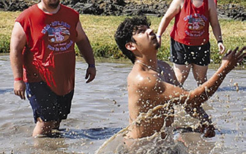 A MUD VOLLEYBALL player goes for the ball last Saturday during Hog Splash 2026 at Slovacek’s in Snook. The popular, annual event benefits Hospice Brazos Valley. Tribune photo by Roy Sanders