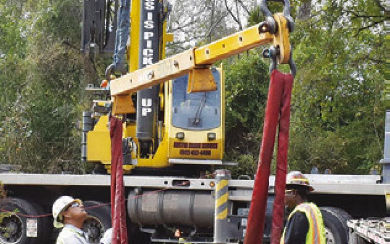 CREWS WORK at the scene of the old iron bridge removal project on County Road 146.
