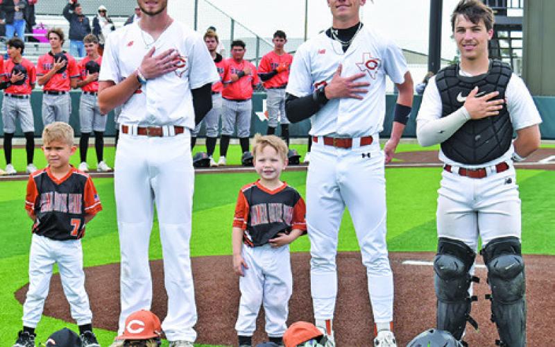 CALDWELL’S CORT HILDEBRAND, Shane Clements and Jake Hibbeler are joined by these Little League players, and future Hornets, for the National Anthem at the Caldwell-Smithville game on Saturday. Tribune photo by Roy Sanders