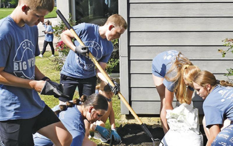 CALDWELL JUNIOR HIGH students cleaned out this flower bed at the Harrie P. Woodson Memorial Library during the school’s annual Big Event which was held last Friday. -- Tribune photo by Roy Sanders