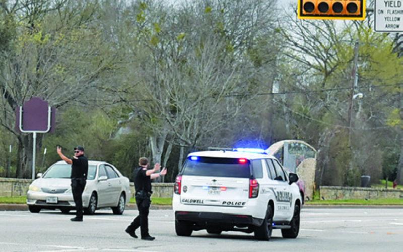 CALDWELL POLICE OFFICERS direct traffic at the State Highway 21 and Main Street intersection on Monday, March 2, during the electric power outage in Caldwell. See story inside.