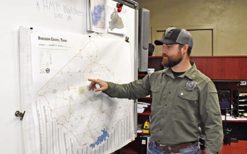 TY ELLER LOOKS at this map in the emergency management office at the Burleson County Courthouse in Caldwell. Tribune photo by Roy Sanders