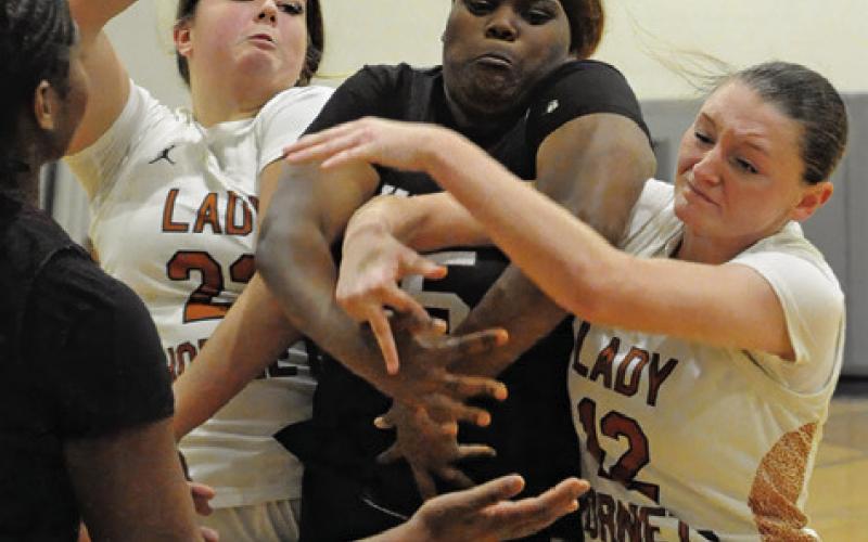CALDWELL PLAYERS, Kierstyn Macik and Kaely Brown, fight with a Hearne player for possession of the ball during Caldwell’s 44-31 win over Hearne last Tuesday night in Hornet Gym. Tribune photo by Denise Squier