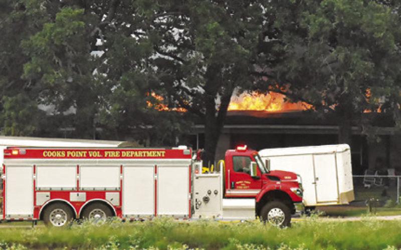 COOKS POINT VOLUNTEER firefighters respond to the scene of this house fire on July 16 on F.M. 1362 South. Tribune photo by Roy Sanders