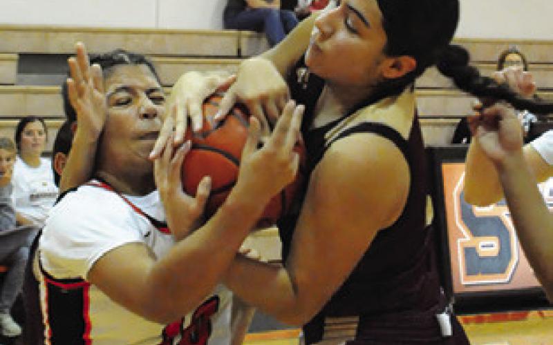 CAPRI ALEJANDRO is sandwiched between to Milano players, fighting for possession of the ball. Tribune photo by Denise Squier