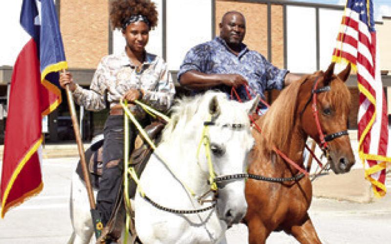 ROGER RICHMOND and his daughter Rachel Richmond carry the flags on Saturday at the annual Juneteenth Parade in Caldwell.