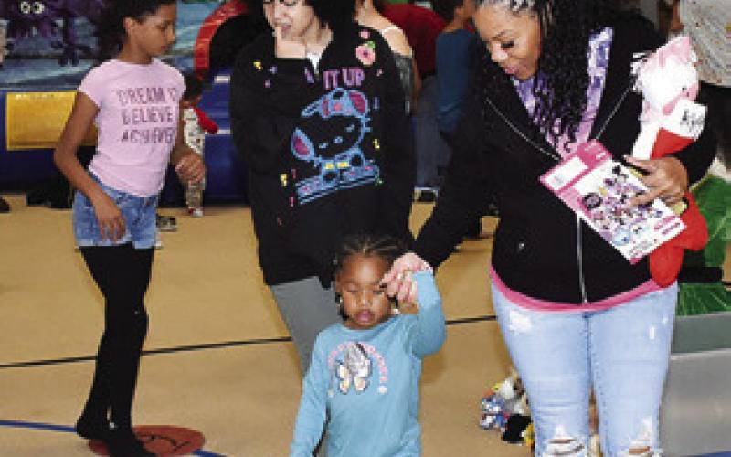 CHILDREN ENJOY THE toy walk on Saturday at the Santaville celebration at the Yegua Center in Somerville.