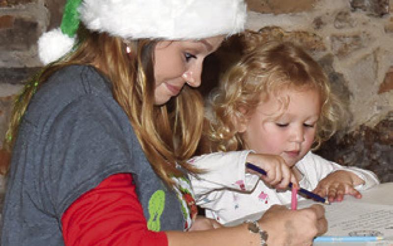 ALLYSON AND Sadie Hargrove write letters to Santa on Saturday at Santaville at the Yegua Center in Somerville.
