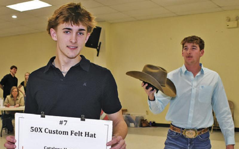 DYLAN CHAPMAN AND Colby Maresh display these items on Saturday night at the annual Go Texan Auction.