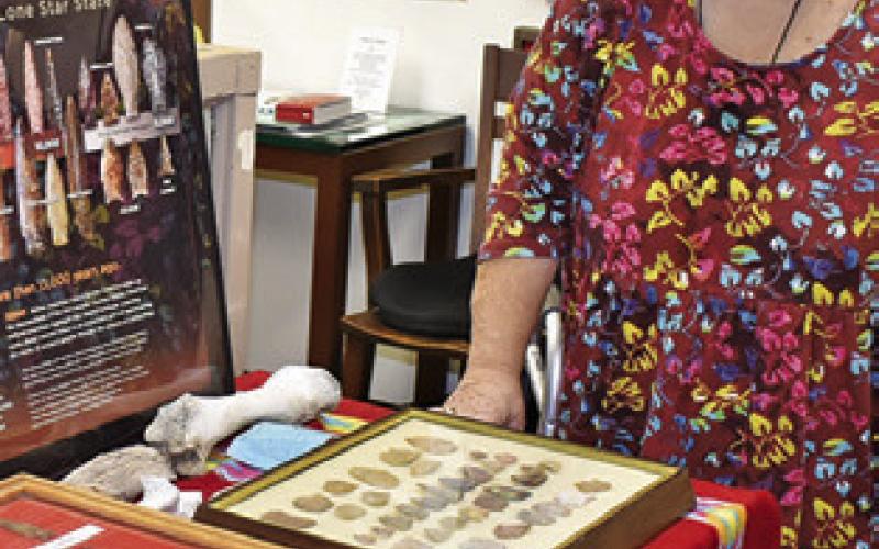 MELYNDA GIESENSCHLAG looks over these items at the Burleson County Museum in the courthouse. Burleson County will celebrate Heritage Week on March 23-28.