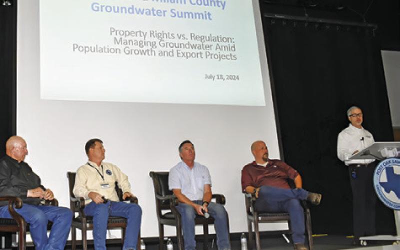 JOHN DUPNIK, AT the podium, moderates a discussion on property rights versus regulation. Also pictured are, from left, Alan Day, Gary Westbrook, Billy Howe and James Totten.