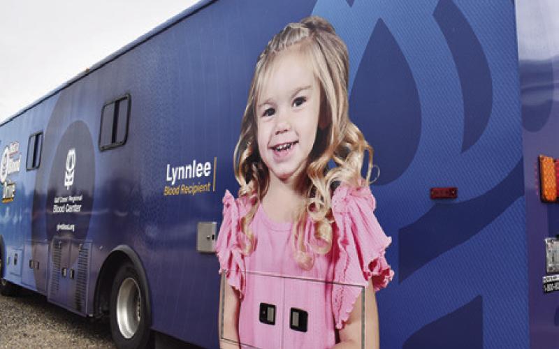LYNNLEE KOCUREK stands next to this picture
