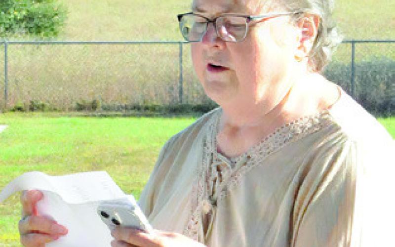 ANN SEBESTA READS the names of veterans whose graves are in the Snook Cemetery during a ceremony last Saturday morning. Tribune photo by Denise Squier