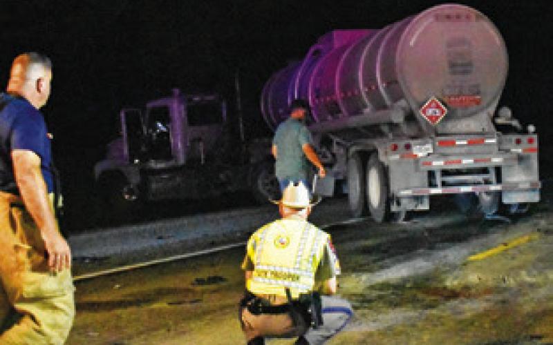 DPS TROOPERS INVESTIGATE at the site of this car-18 wheeler collision early Monday on State Highway 36 South. Tribune photo by Roy Sanders