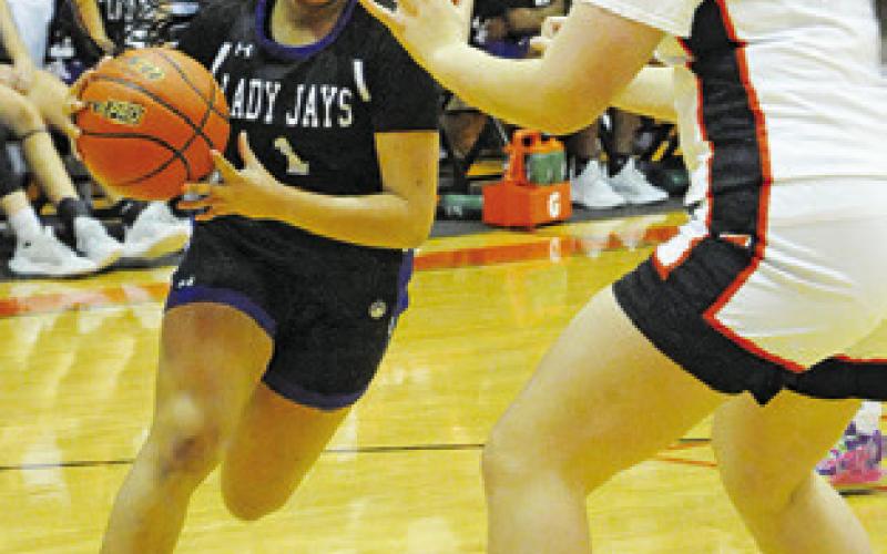 ALANA STRINGFELLOW drives to the basket while Gracee Greiffenstein defends during the Snook-Somerville game last Tuesday. Tribune photo by Denise Squier