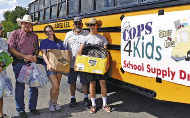 COPS 4 KIDS HOLDS their school supply drive on Monday at the Walmart parking lot. Pictured are Peter Glidewell, Burleson County Sheriff Bill Rios, Alyssa Schenk and Michael and Wyatt Hester.