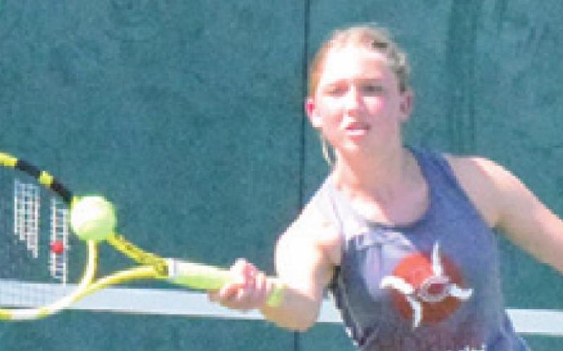 CALDWELL’S TILLY Hicks returns serve during a girls doubles match in Franklin last Thursday. -- Tribune photo by Denise Squier