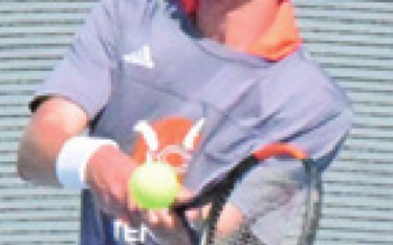 CALDWELL’S GABE PIPES backhands the ball during his mixed doubles match last Thursday. -- Tribune photo by Denise Squier