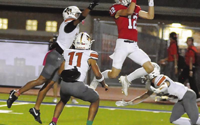 CALDWELL’S DYLAN CARTER, Zane Brown and Krush Strange defend as this Madisonville receiver makes a catch. Tribune photo by Denise Squier