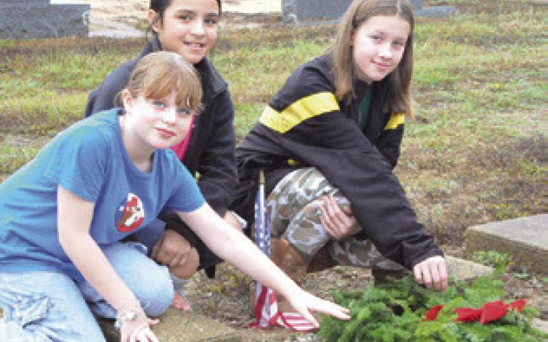 THESE GIRLS placed a wreath on a veteran’s grave in the Snook Cemetery as part of the Wreaths Across America campaign. The event was headed by the Snook Extension Education Association (EEA). Tribune photo by Denise Squier