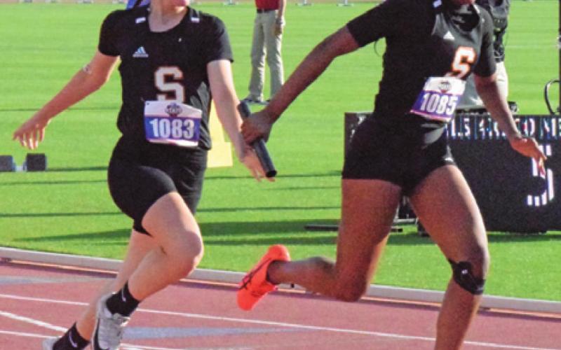 SOMERVILLE’S EMMA KOVASOVIC passes the baton to Xadria Martin during the Class 2A 4x200-meter relay at the UIL State Track and Field Meet on Friday. -- Tribune photo by Denise Squier