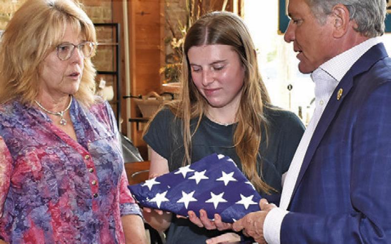 U.S. REP. MICHAEL McCaul presents this U.S. Flag to Sherri Hermes, left, and Caylee Hermes, center, in honor of former Burleson County Sheriff Gene Hermes, who recently died after a long law enforcement career in the county. McCaul presented the flag on Tuesday, June 17, at Lissa’s Sip &amp;amp; Shop in downtown Caldwell.
