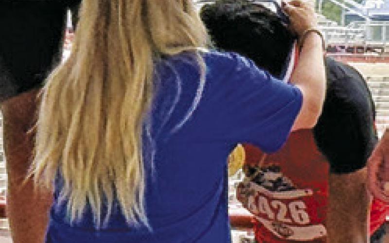 JEREMY VELA is draped with his gold medal by a UIL official at the UIL State Track &amp;amp; Field Meet in Austin last week. Tribune photo by Denise Squier