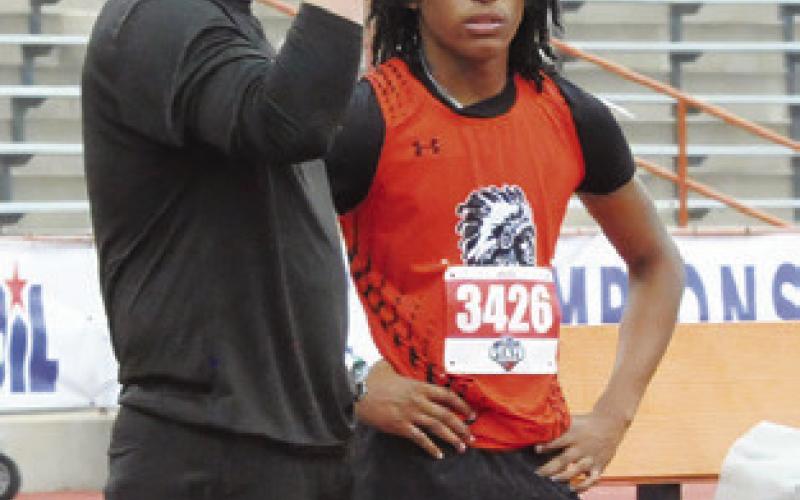 COACH LUKE KLINGLER talks to Jeremy Vela during the boys Class 2A high jump at last week’s the UIL State Track &amp;amp; Field Meet. Tribune photo by Denise Squier