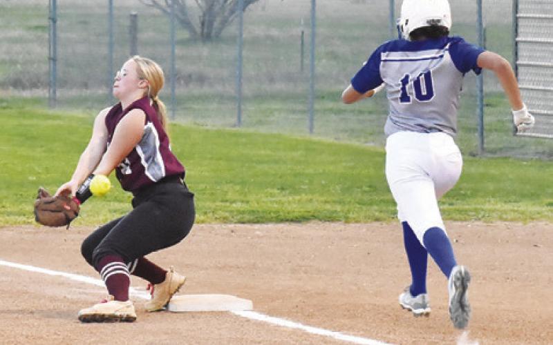 THE IOLA FIRST BASEMAN misses the throw while Jazmena Perez makes it safely to first base. -- Tribune photo by Roy Sanders