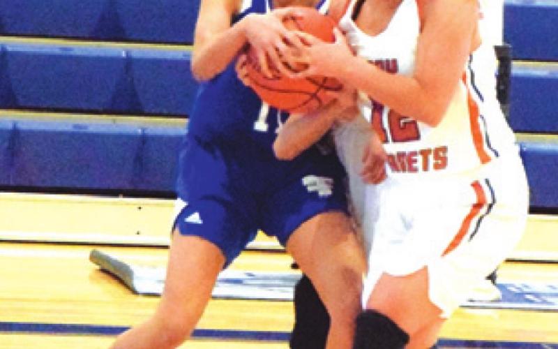 CALDWELL’S MACY NARRO fights for possession of the ball with a player from Victoria St. Joseph last week at Hornet Gym.