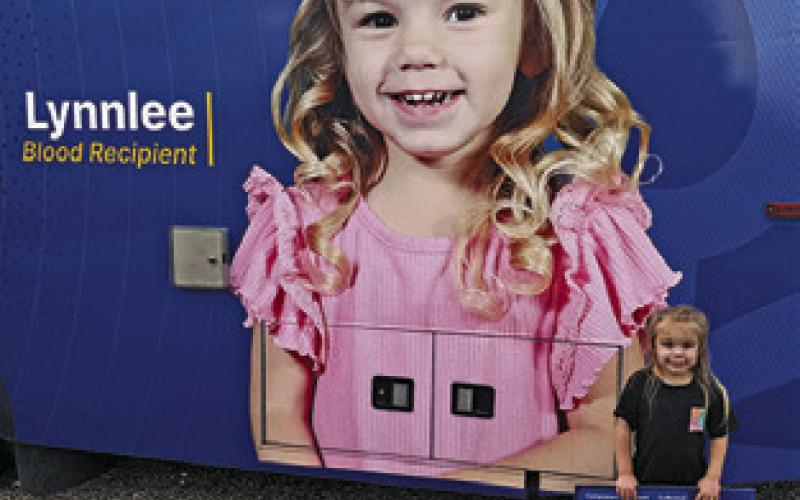 LYNNLEE KOCUREK stands next to this picture of herself on the blood donor van last Sunday at the Deanville Volunteer Fire Department. A replenishment blood drive was held.