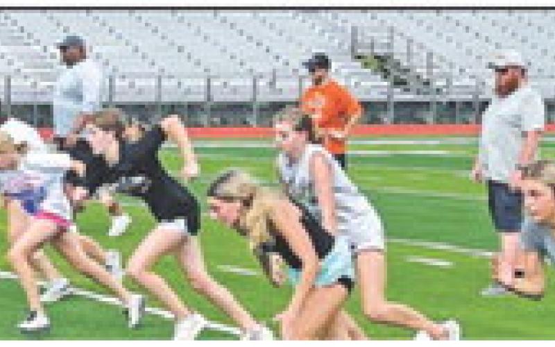 STUDENTS RUN FROM THE YARD LINE while coaches look on during this summer’s Caldwell athletic Strength and Conditioning Camp at Caldwell High School.
