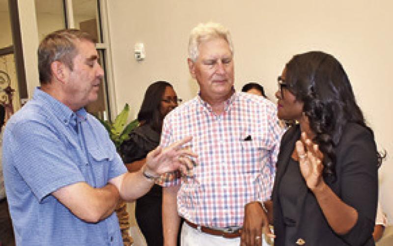 TONY ZACCAGNINO and Robert Lee of the Burleson County Hospital District Board talk to Rochelle Adams at the clinic celebration.