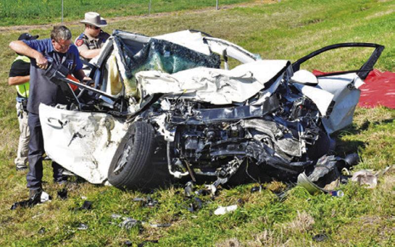 CALDWELL FIRE CHIEF David Pevehouse and a DPS trooper look over the wreckage at the scene. -- Tribune photo by Roy Sanders
