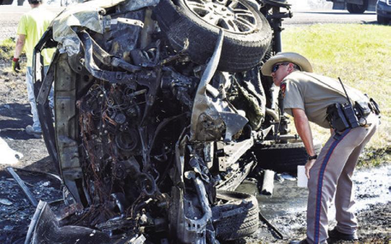 A DPS TROOPER looks at the wreckage of this pickup at the scene.