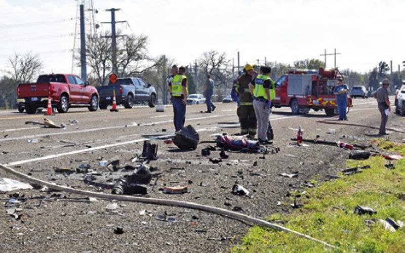 DEBRIS FROM THE accident wreckage is scattered on the road.