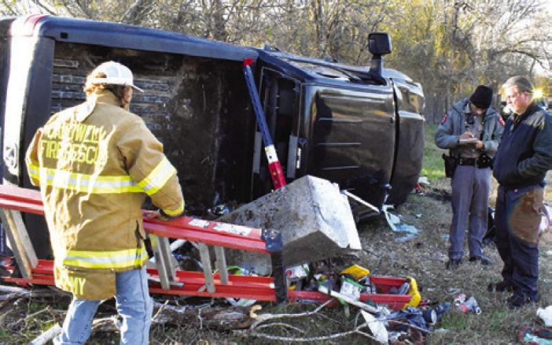 FIREFIGHTERS AND DPS troopers respond to the scene of this fatal accident early Monday off County Road 123. Tribune photo by Roy Sanders