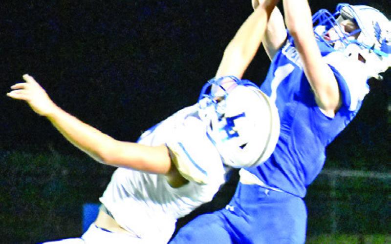 LIAM ZEQUEIRA REACHES high to try to intercept this pass last Friday in Snook’s 35-22 loss to Louise. -- Tribune photo by Roy Sanders